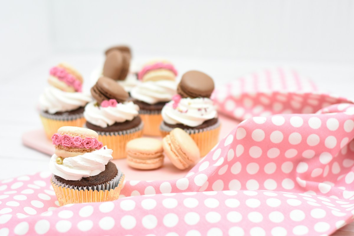 An assortment of colourful macarons and cupcakes